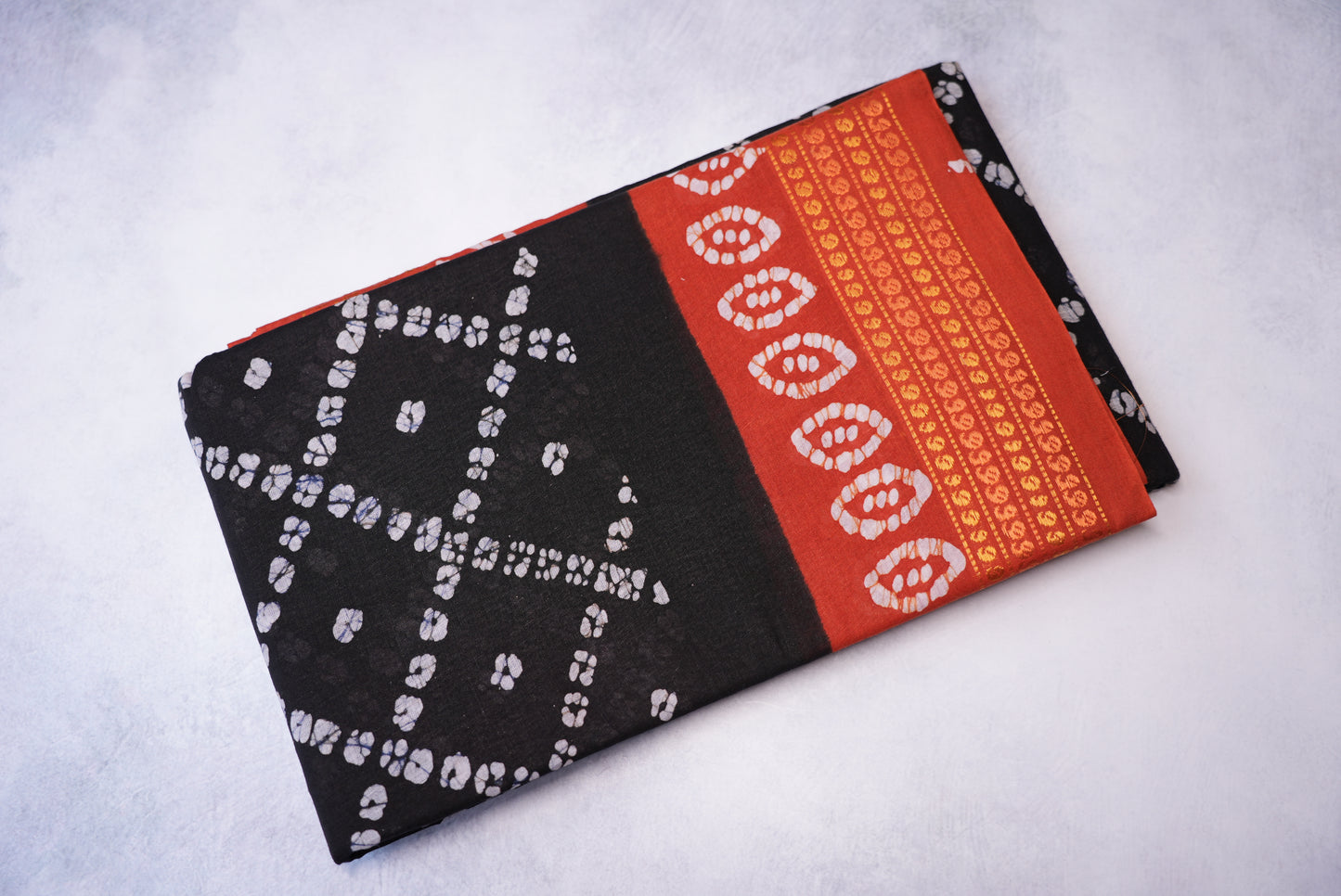 Batik Cross Print Black Saree with Orange Border