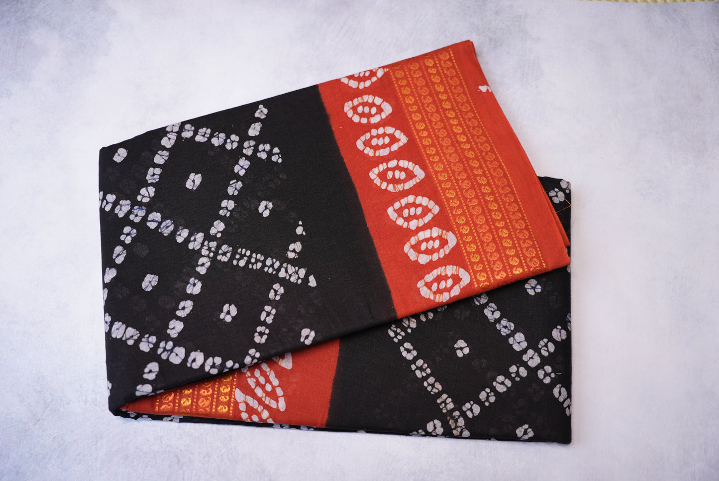 Batik Cross Print Black Saree with Orange Border