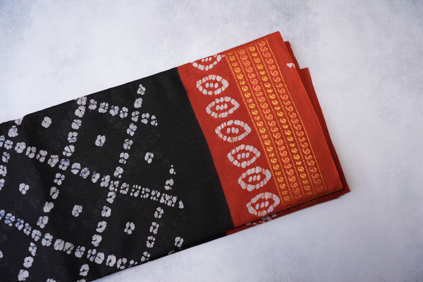 Batik Cross Print Black Saree with Orange Border